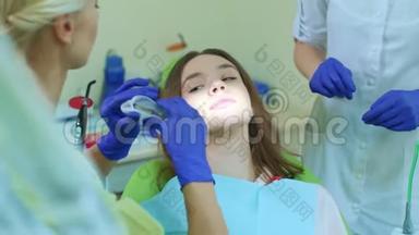 牙医与助理准备女孩美白牙齿。 美白程序